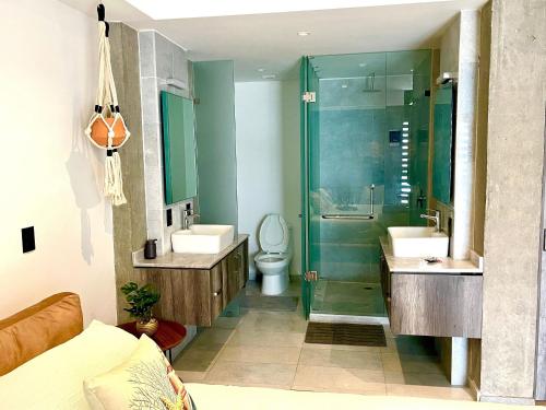 a bathroom with two sinks and a shower and a toilet at Espectacular diseño, terraza con Hamaca y Jacuzzi in Guadalajara