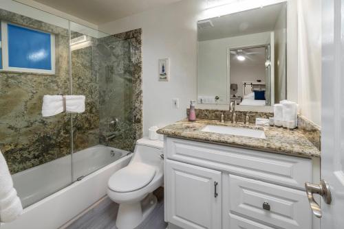 a bathroom with a toilet and a sink and a shower at 8BR Beach Duplex with Ocean Views, Patio & Pool Table in Newport Beach