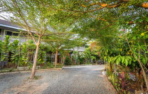 a walkway in front of a building with trees at Sanssouci Kep in Kep