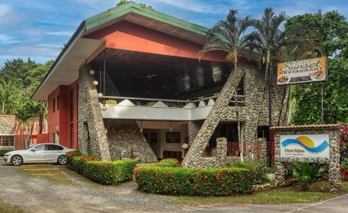 a hotel with a car parked outside of it at Hotel Playa Bejuco in Esterillos Este