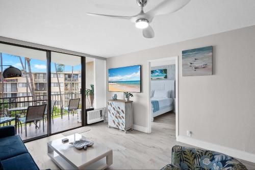 a living room with a couch and a room with a bed at Kanai a Nalu 314 - Newly Renovated, Oceanfront, AC in Wailuku