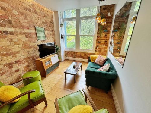 a living room with a couch and a tv at Park views, fast wifi, washer & dryer in Auckland