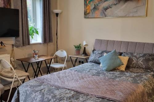a bedroom with a bed and a table and chairs at Spacious Studio with Free Parking West Molesey KT8 in West Molesey