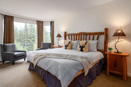 a bedroom with a bed and a chair and a window at 2BR plus den Ski in Ski out Condo with Pool and Hot Tub by Harmony Whistler in Whistler