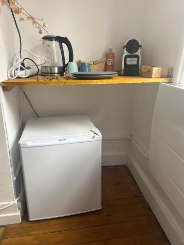 - un petit réfrigérateur blanc sous un comptoir dans la cuisine dans l'établissement Le Rêve Cosy, Studio Équipé, à Arras