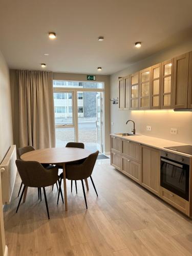 a kitchen with a table and chairs in a kitchen at Erobik Apartments in Höfn