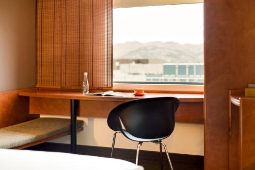 a desk and a chair in a room with a window at Ibis Christchurch in Christchurch