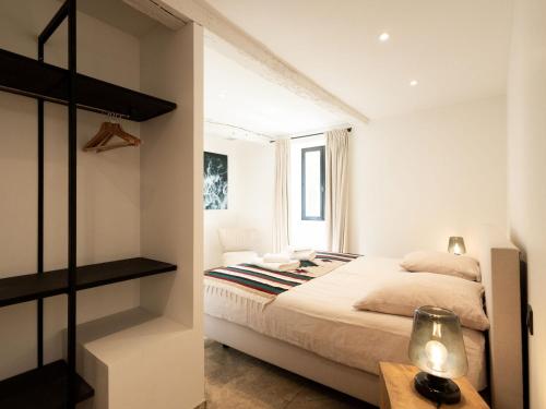 a white bedroom with a bed and a table at Peyrusse Peace Pool & Charm in Peyrusse-Grande