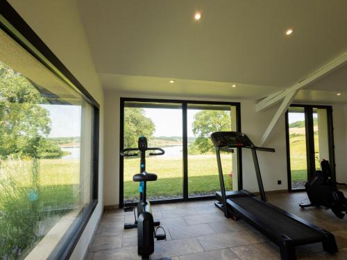 a gym with two exercise bikes and a large window at Peyrusse Peace Pool & Charm in Peyrusse-Grande