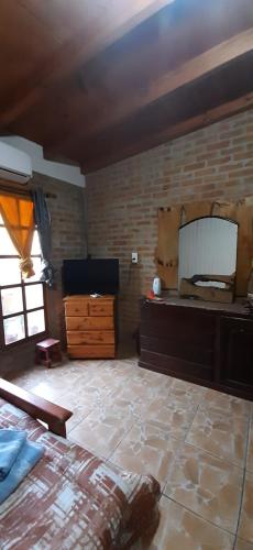 a bedroom with a bed and a brick wall at Monte Guesthouse in Puerto Libertad