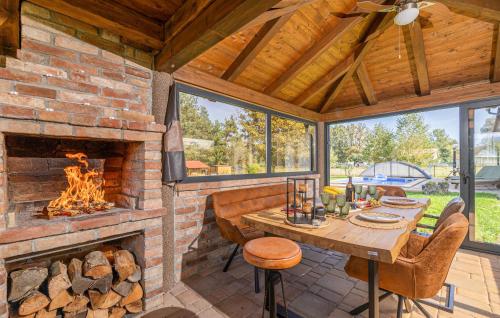 a living room with a brick fireplace and a wooden table at Awesome Home In Gospic With Wifi in Gospić