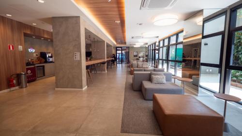 a lobby with couches and tables in a building at Apezinho Moema in Sao Paulo