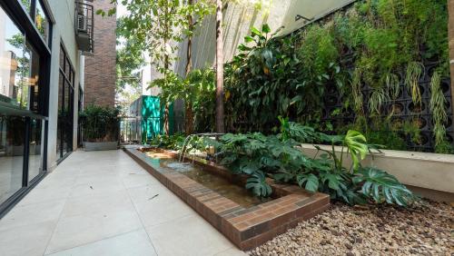 a garden in the middle of a building with plants at Apezinho Moema in Sao Paulo
