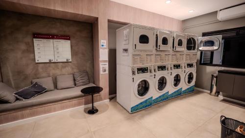 a laundry room with two washing machines and a couch at Apezinho Moema in Sao Paulo