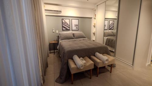 a bedroom with a bed and a large mirror at Apezinho Moema in Sao Paulo