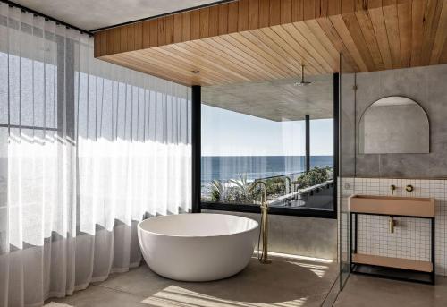 a bathroom with a tub and a large window at Bunker House, Gerringong in Gerringong