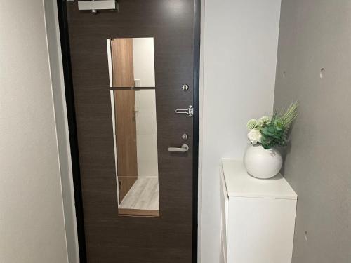 a door with a mirror on top of a toilet at COMMA HOUSE Otsuka 4-1 in Tokyo