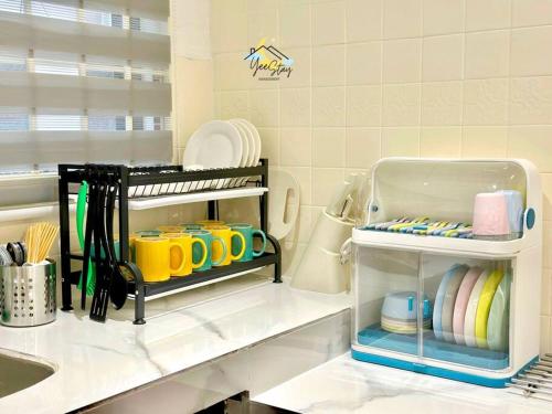 a kitchen counter with plates and utensils on a shelf at Kampung8 17pax Snooker Arcade in Melaka