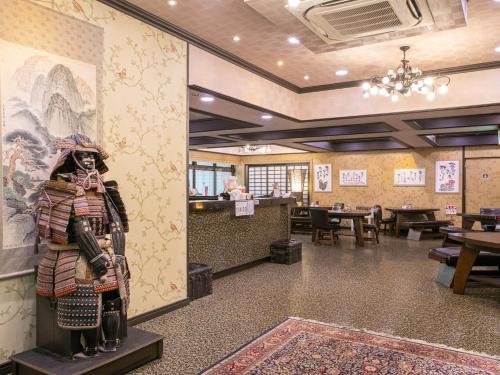 a restaurant with a statue in the middle of a room at Yufuin Besso Shikisai Hotel in Yufuin