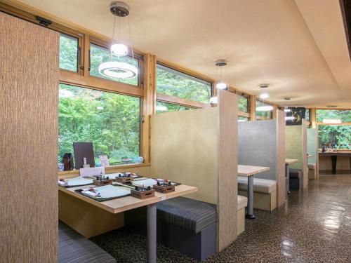 a room with a desk and some windows at Yufuin Besso Shikisai Hotel in Yufuin