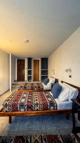two beds in a large room with a large bedvisor at Constantino Hostel by lo de Guille in El Chalten