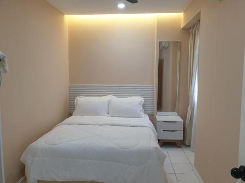a bedroom with a bed with white sheets and pillows at Sri Raya Apartment Bandar Baru Bangi in Kajang