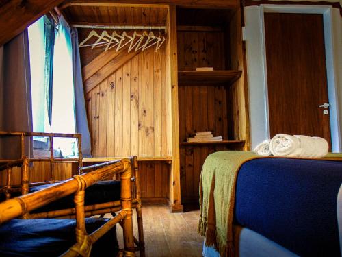 a bedroom with two beds and a wooden wall at Constantino Hostel by lo de Guille in El Chalten