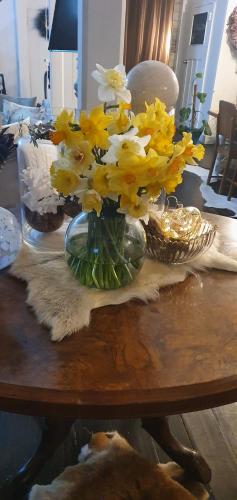 a vase filled with yellow flowers on a table at Belle Ame in Takapau
