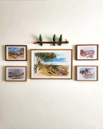 a row of framed pictures on a wall at SJC Funcional e Aconchegante in São José dos Campos