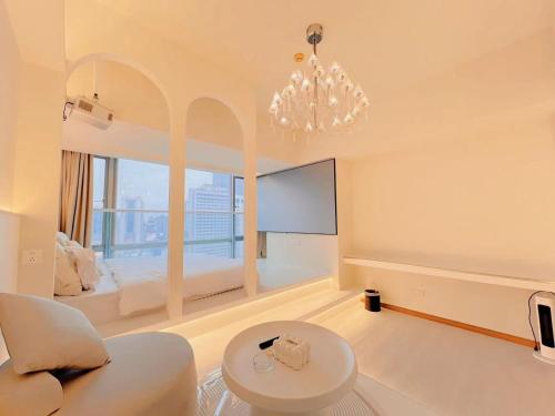 a large white room with a chandelier and a bed at Youlejia Projection Apartment Guangzhou Beijing Road Pedestrian Street Branch in Guangzhou