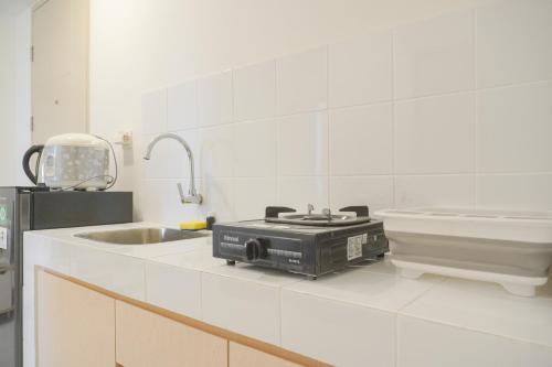 a kitchen with a toaster on a counter next to a sink at New Furnished and Homey 2BR at Tokyo Riverside PIK 2 Apartment By Travelio in Rawalembang