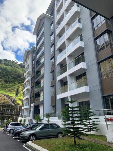 a large apartment building with cars parked in front of it at Cameron Palas Homestay - Sunrise View in Brinchang