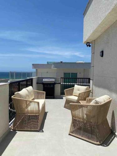 a group of chairs sitting on top of a balcony at Cobertura Temporada -Dream Cabo Frio in Škorak