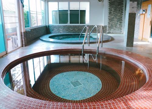 a pool in a building with two jacuzzis at Eastpana Executive Residence 304 Prachinburi in Si Maha Phot