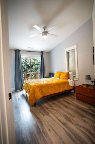 a bedroom with a bed with yellow sheets and a window at Urban Nest Guest House in Charlotte