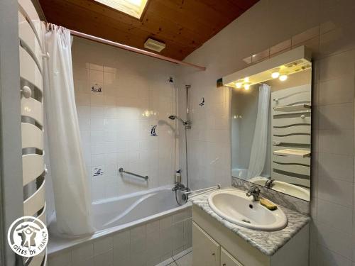 une salle de bain avec une baignoire et un lavabo et une baignoire dans l'établissement Charmante maison en lisière de forêt à Noirmoutier, proche plage et Passage du Gois - FR-1-426-563, à Barbâtre