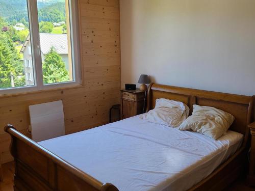 une chambre avec un lit avec des draps blancs et une fenêtre dans l'établissement Appartement confortable 4 pers, 2 chambres, proche centre, balcon & WiFi, Villard-de-Lans - FR-1-689-137, à Villard-de-Lans