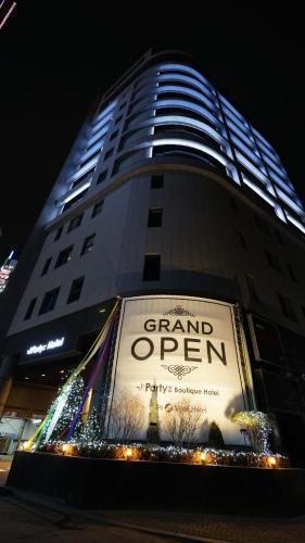 a tall building with a giant open sign on it at Suwon Partyz Hotel in Suwon