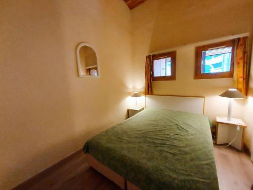 - une chambre avec un lit vert et 2 fenêtres dans l'établissement Charmant T2 6 pers avec balcon à 200m des pistes - FR-1-353-148, à La Plagne Tarentaise