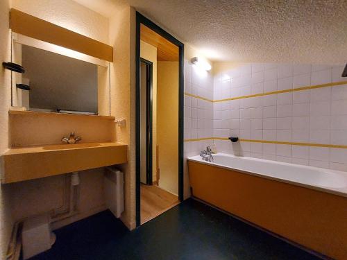 une salle de bain avec une baignoire, un lavabo et un miroir dans l'établissement Charmant T2 6 pers avec balcon à 200m des pistes - FR-1-353-148, à La Plagne Tarentaise
