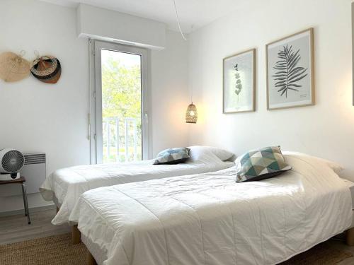 - 2 lits dans une chambre blanche avec fenêtre dans l'établissement Appartement moderne 4 pièces à Cavalière, proche plage - FR-1-251-826, au Lavandou