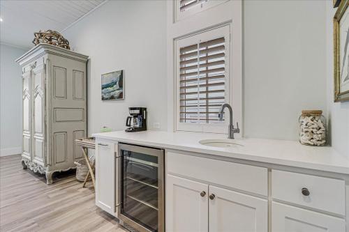 cocina blanca con fregadero y armario en Isle Be Back 238 LAK, en Mustang Beach