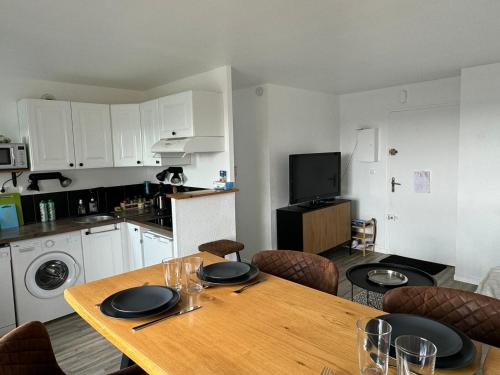 une cuisine avec une table en bois et des chaises ainsi qu'une salle à manger dans l'établissement Cabourg: Appartement 2 Pièces, Proche Plage, Balcon, WiFi - FR-1-487-374, à Cabourg