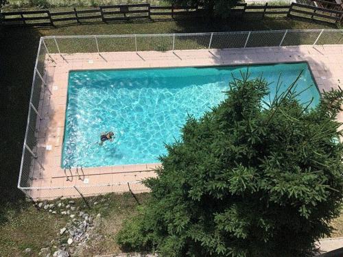 - une vue sur la piscine avec une personne dans l'eau dans l'établissement Appartement rénové 2 pièces cabine avec balcon et accès piscine - Méribel - FR-1-180-637, à Les Allues