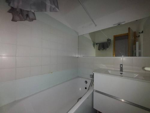 une salle de bain blanche avec une baignoire et un lavabo dans l'établissement Appartement 2 pièces avec balcon pour 6 personnes à La Plagne-Tarentaise - FR-1-353-147, à La Plagne Tarentaise