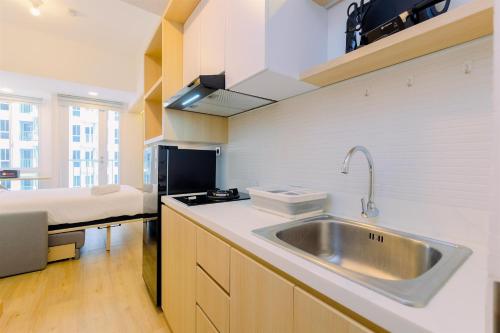 una cucina con un lavandino e un letto in una stanza di Simply Look and Cozy Studio Tokyo Riverside PIK 2 Apartment By Travelio a Rawalembang