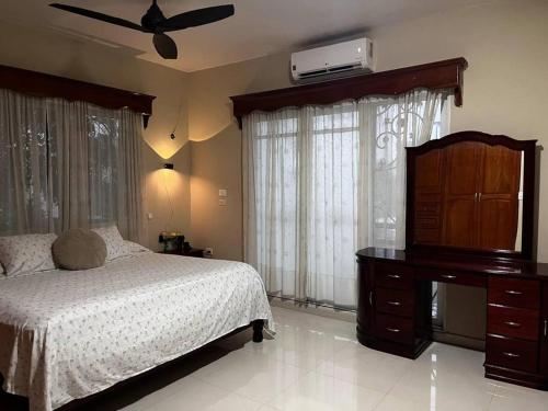ein Schlafzimmer mit einem Bett und einer Kommode und einer Kommode mit einem Kleid in der Unterkunft Casita Cacao Canela in Villahermosa
