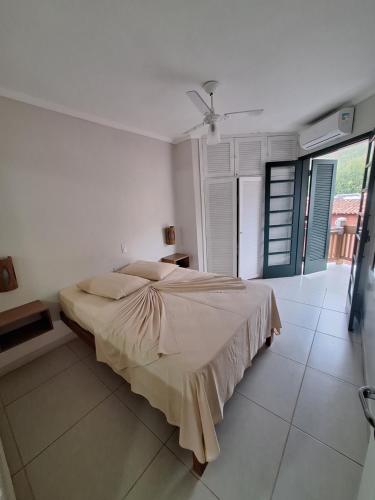 una camera da letto con un letto grande in una stanza bianca di Flat Porto Paúba a Pauba