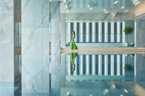 a woman in a green dress standing in a pool at InterContinental Shenzhen WECC by IHG in Shenzhen