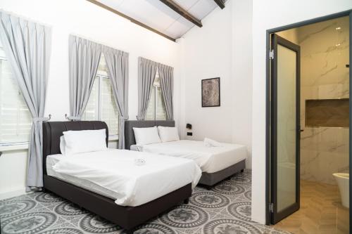 two beds in a room with a mirror at Jovial Industrial Stylish Lodge ````Bukit Mertajam in Bukit Mertajam